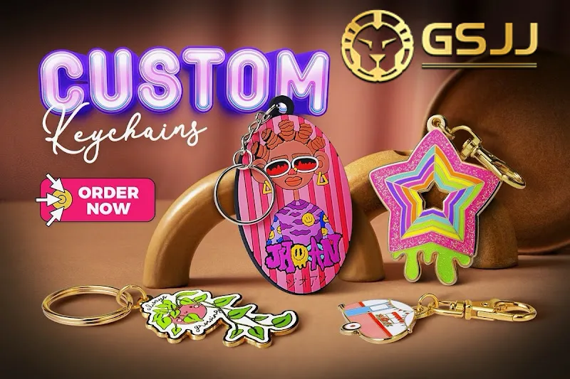 A promotional image for GSJJ Custom Keychains, displaying four unique keychains: a vibrant oval keychain with an illustrated character, a pink and green glittery star keychain, a white and green floral keychain, and a small camper van keychain, set against a dark background with "CUSTOM Keychains" text.