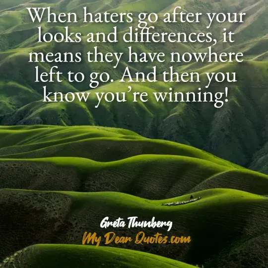 A quote from Greta Thunberg against a background of rolling green hills, showing a textured landscape. The quote reads: "When haters go after your looks and differences, it means they have nowhere left to go. And then you know you're winning!" Below the quote, it says "Greta Thunberg" and "My Dear Quotes.com".