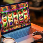 Person playing a vibrant online slot machine game on a laptop at a cozy setting