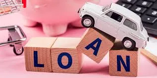 Wooden blocks spelling "LOAN" with a toy car on top, symbolizing car loan decisions.