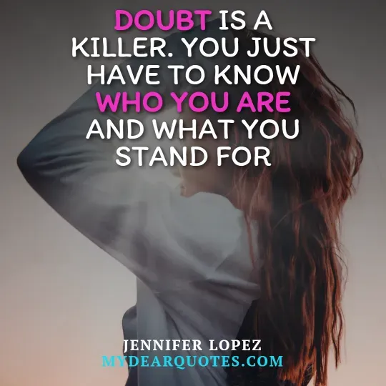 A close-up, blurred image of a woman with long, flowing brown hair, seen from behind or the side, against a softly lit, plain background. Overlaying the image is the quote "DOUBT IS A KILLER. YOU JUST HAVE TO KNOW WHO YOU ARE AND WHAT YOU STAND FOR." The words "DOUBT" and "WHO YOU ARE" are highlighted in pink. The quote is attributed to Jennifer Lopez, with "MYDEARQUOTES.COM" visible below.