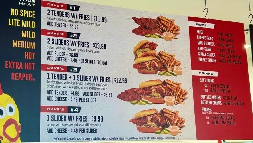 A close-up of the Dave's Hot Chicken menu board, displaying "Your Heat" levels from No Spice to Reaper, and detailing combo options like "2 Tenders W/ Fries" ($11.99), "2 Sliders W/ Fries" ($13.99), "1 Tender + 1 Slider W/ Fries" ($12.99), and "1 Slider W/ Fries" ($9.99), along with sides, drinks, and shakes, providing a comprehensive look at the offerings inside the Dave's Hot Chicken Menu.