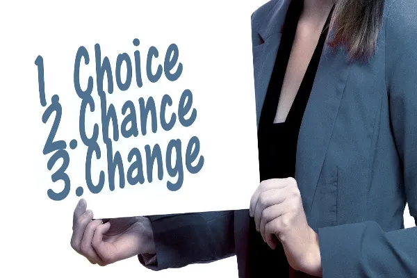 A person holding a sign that lists "1. Choice, 2. Chance, 3. Change."