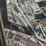 An aerial view looking down on Jumeirah Beach Residence (JBR) in Dubai, showcasing waterfront properties, roads, and a construction site, highlighting its urban and investment potential.