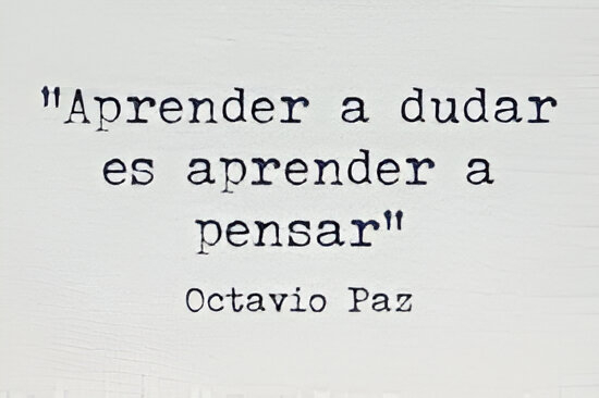 The quote "Aprender a dudar es aprender a pensar" by Octavio Paz typed on a white background.