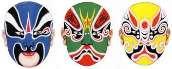 Three distinct Chinese opera masks ('Lianpu') displayed side-by-side. From left to right: a blue mask with white and black patterns symbolizing fierceness, a green mask with red and black designs indicating impulsiveness, and a yellow mask with red and black accents representing cunning. Each mask features exaggerated facial features and traditional color symbolism.