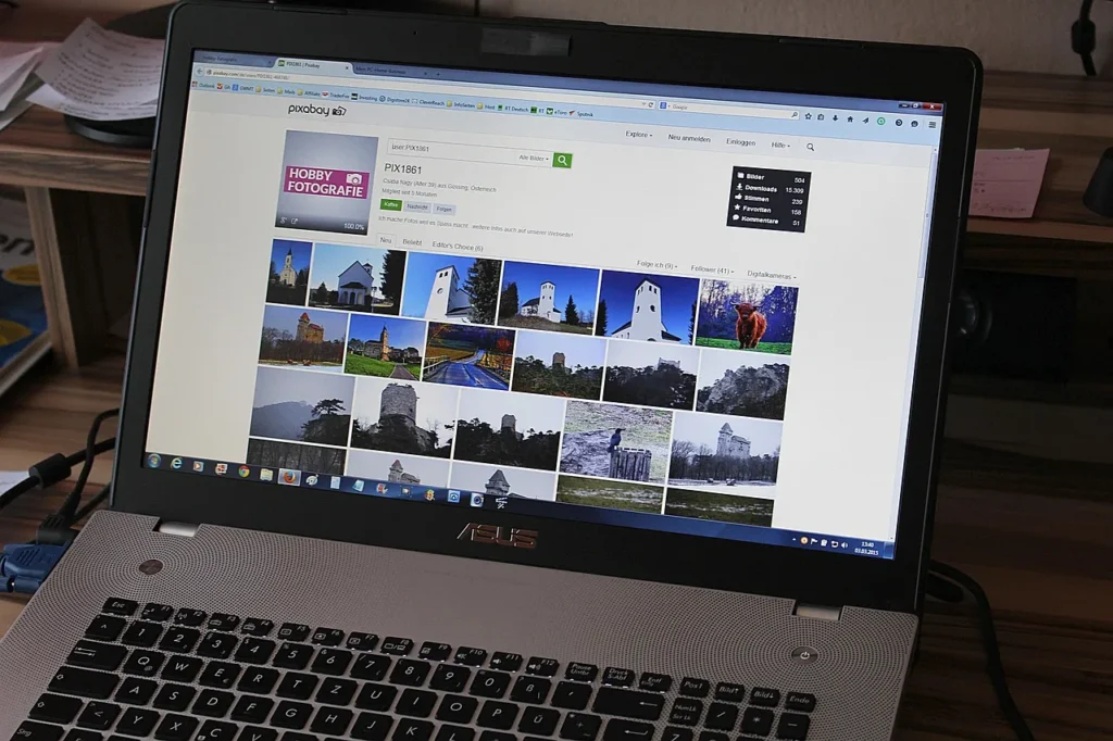 A laptop displaying a photo stock website with various landscape and architectural images, suggesting content curation for a nonprofit website.