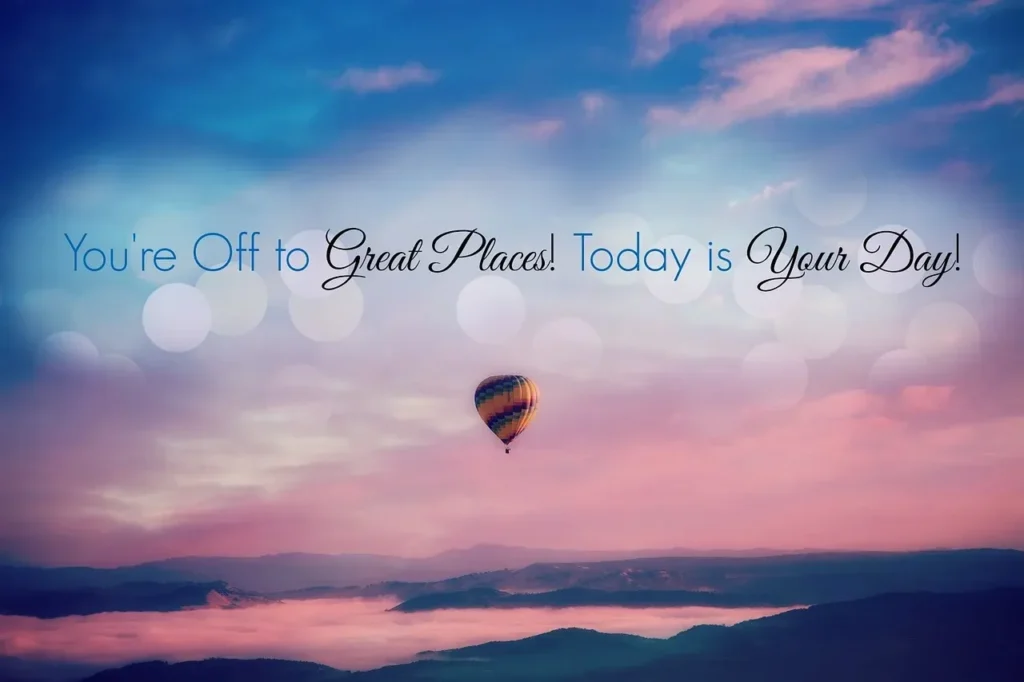 A colorful hot air balloon floats over misty mountains at sunrise, with the inspiring quote: "You're Off to Great Places! Today is Your Day!" overlaying the sky.